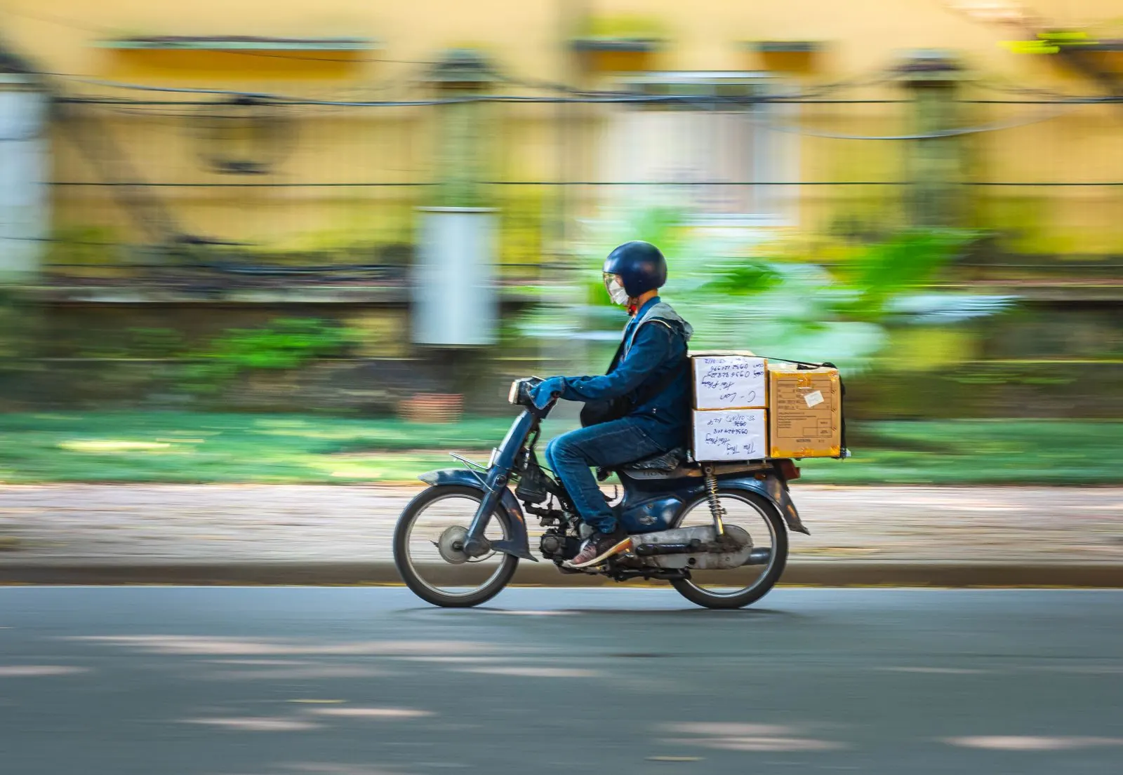 A courier on a motorbike carrying parcels